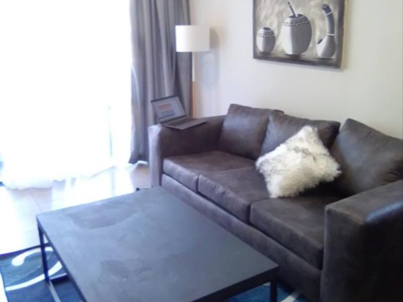 A living room area featuring tiled flooring and a sliding glass door providing natural light.