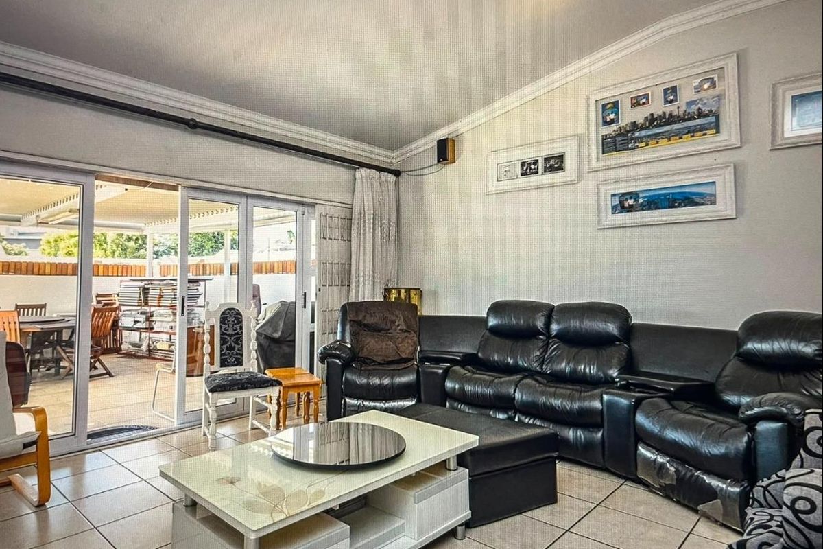 Spacious living room featuring tiled flooring and large sliding glass doors providing direct access to the outdoor patio area.