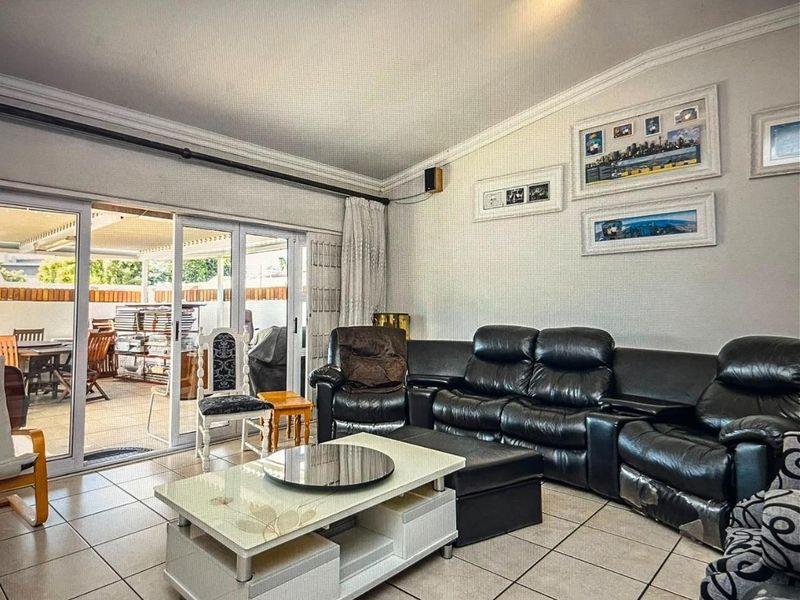 Spacious living room featuring tiled flooring and large sliding glass doors providing direct access to the outdoor patio area.