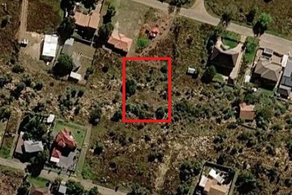An aerial view of a vacant residential plot highlighted in red, situated within an established neighborhood.