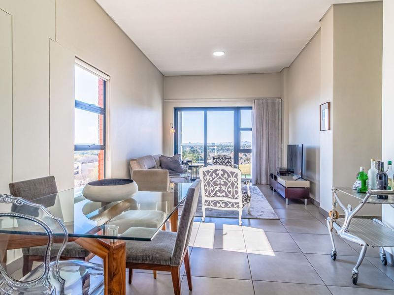 Spacious open-plan living and dining area featuring large sliding glass doors that provide ample natural light and access to the balcony.