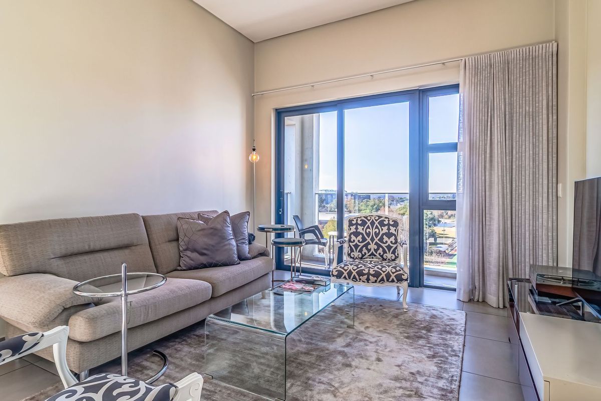 A bright living room featuring large sliding glass doors that provide natural light and access to an outdoor balcony area.