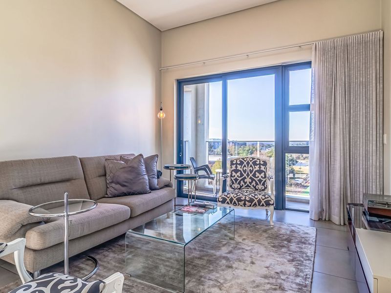 A bright living room featuring large sliding glass doors that provide natural light and access to an outdoor balcony area.