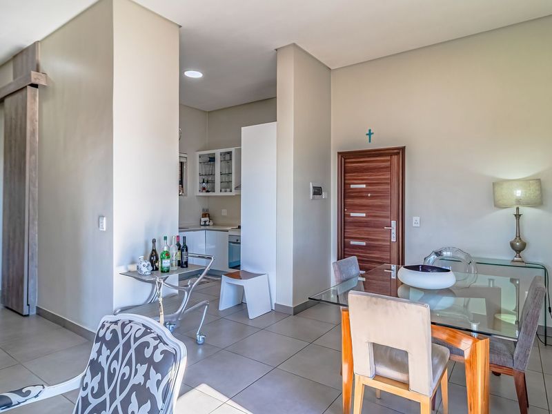 Open plan living and dining area featuring tiled floors, recessed lighting, and a modern kitchen with built-in cabinetry and appliances.
