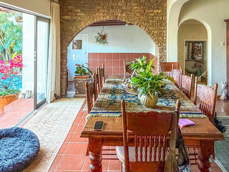 Spacious dining area featuring rustic exposed brick archways, terracotta flooring, and seamless access to the outdoor pool area through large sliding glass doors.