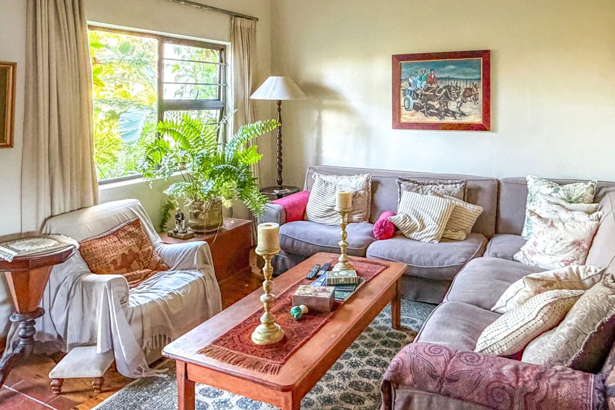 A comfortable living room featuring terracotta floor tiles and a large window, providing a warm and inviting atmosphere for relaxation.