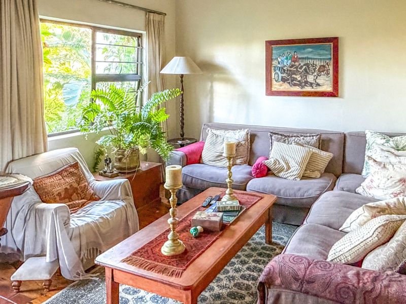 A comfortable living room featuring terracotta floor tiles and a large window, providing a warm and inviting atmosphere for relaxation.