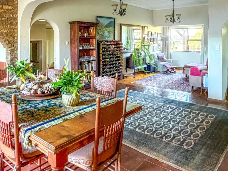 Spacious open-plan living and dining area featuring classic arched doorways, exposed brick accents, and durable tiled flooring throughout.