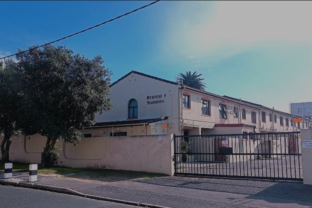 Street view of Byrnesi F Mansions apartment complex featuring a secure gated entrance and paved driveway.