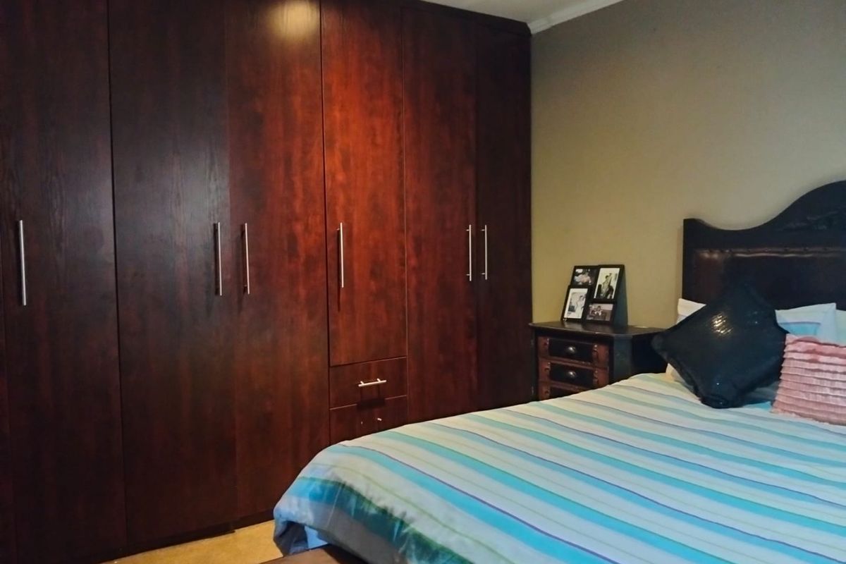 A bedroom featuring dark wood built-in cupboards providing ample storage space.