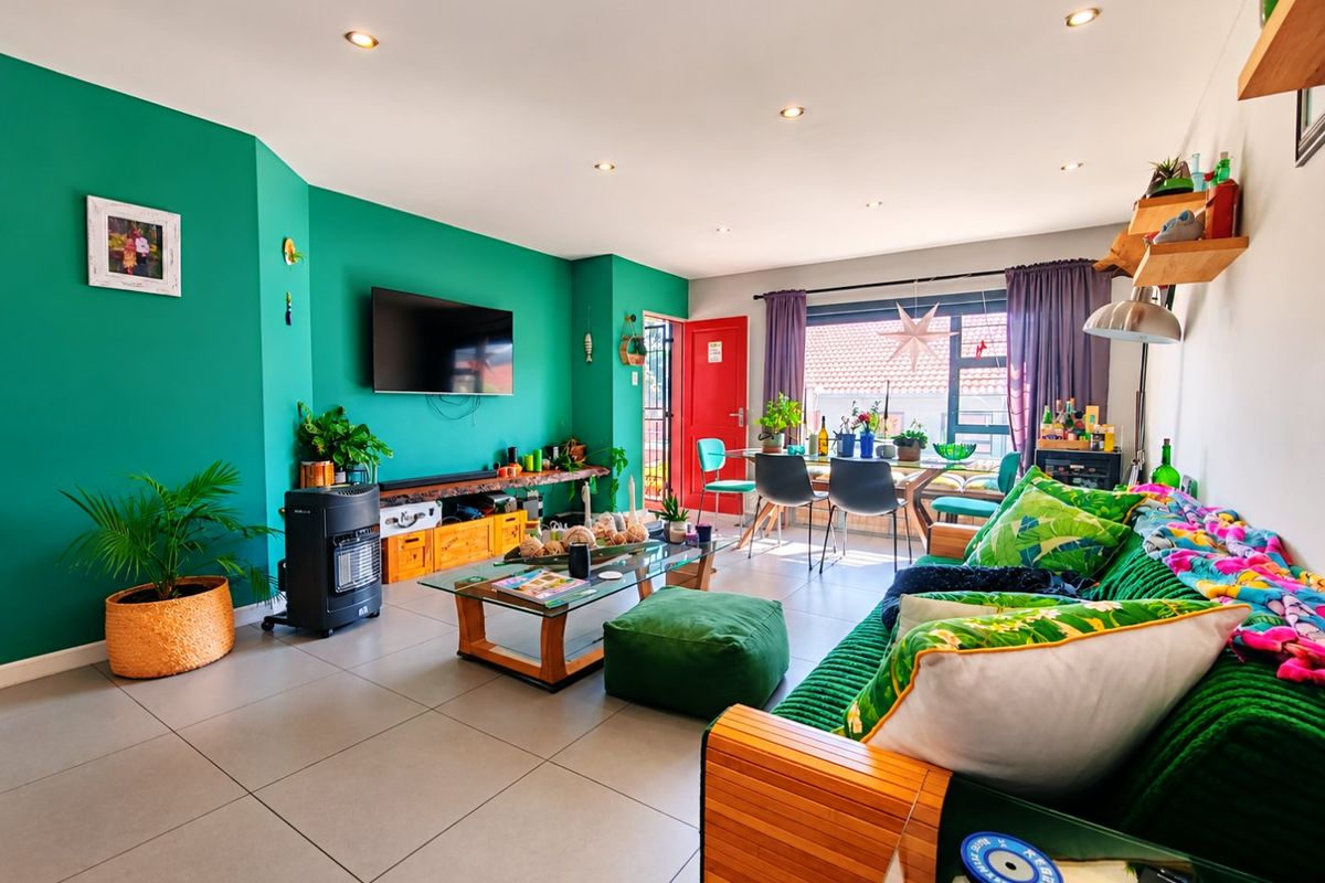 Spacious open-plan living and dining area featuring modern tiled flooring, recessed downlighting, and large windows providing natural light.