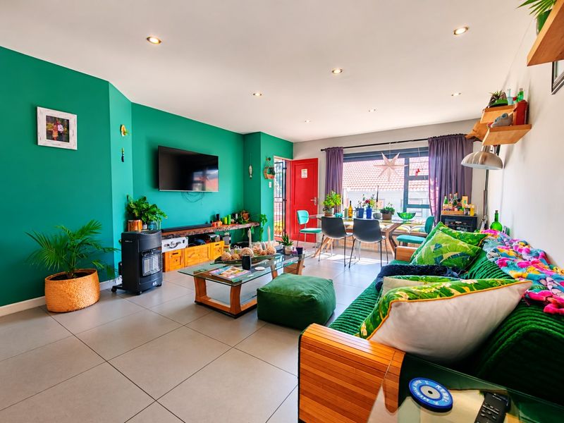 Spacious open-plan living and dining area featuring modern tiled flooring, recessed downlighting, and large windows providing natural light.