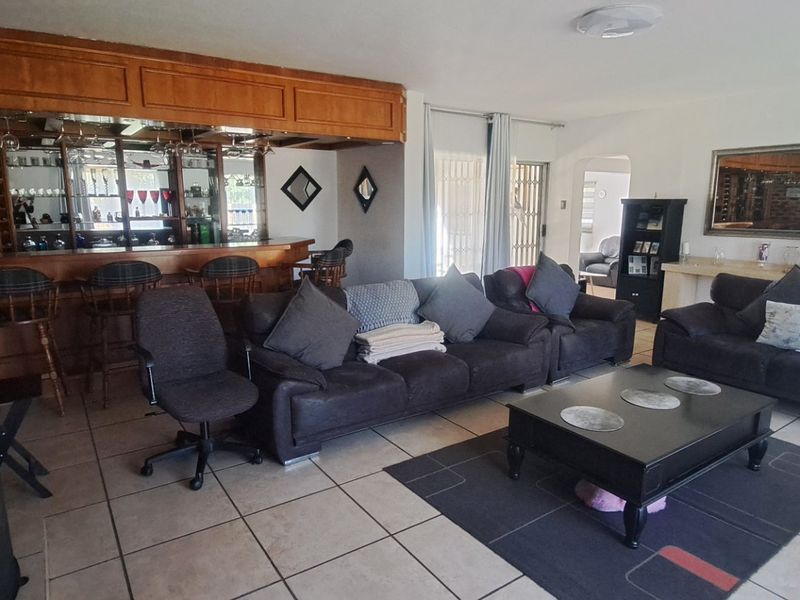 Spacious living room featuring a built-in bar, fireplace, and tiled flooring, offering a comfortable area for relaxation and entertaining.