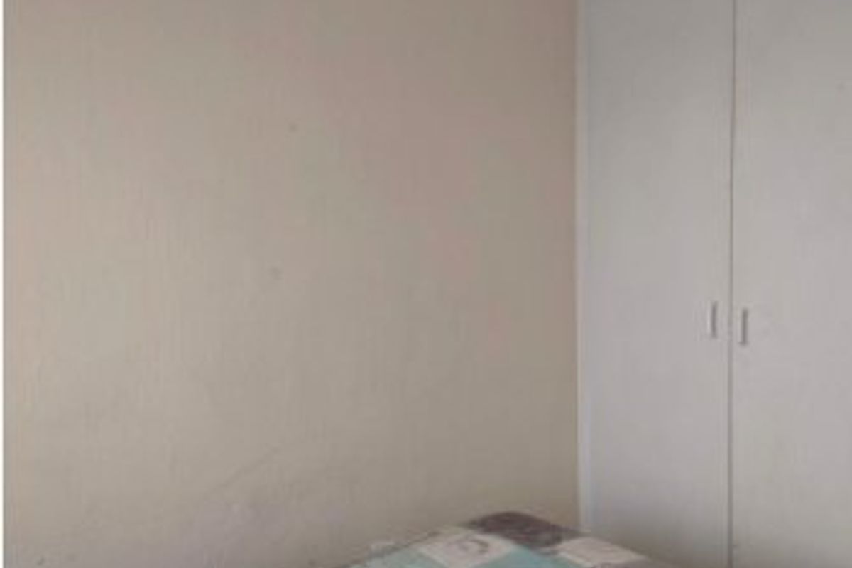 A bedroom featuring a built-in wardrobe with white doors.