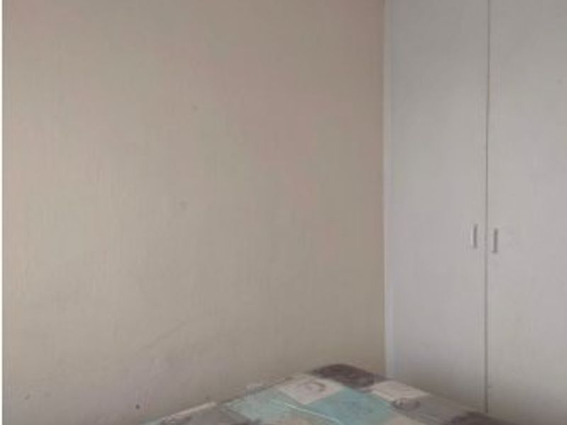 A bedroom featuring a built-in wardrobe with white doors.