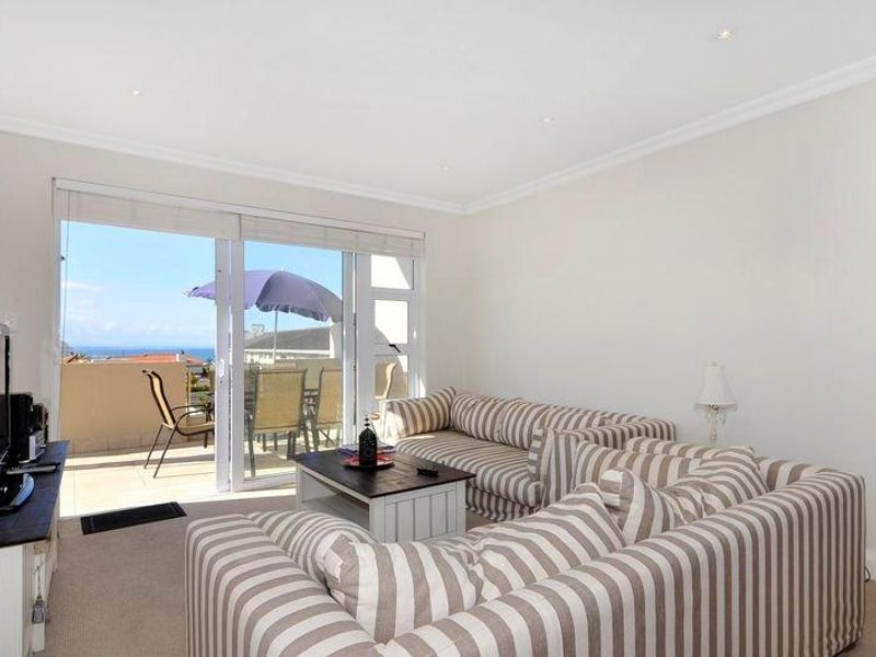 Bright living room featuring recessed downlights and large sliding glass doors providing direct access to a balcony with scenic views.