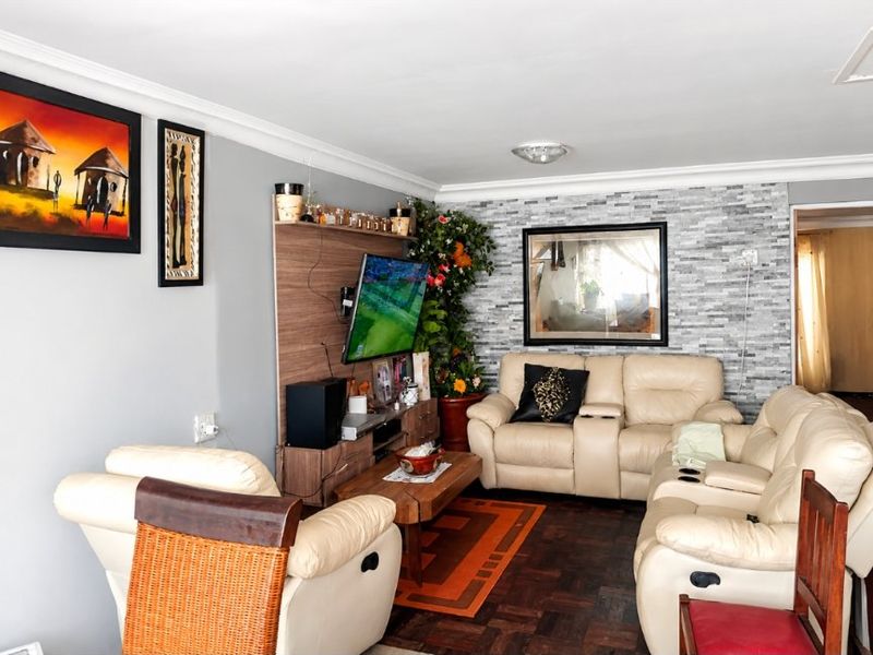 A living room featuring parquet flooring and a stone veneer accent wall, providing a textured focal point in the space.