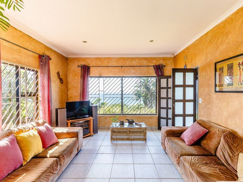 A living room featuring tiled flooring, security bars on windows, and a french door, offering a functional space with natural light.