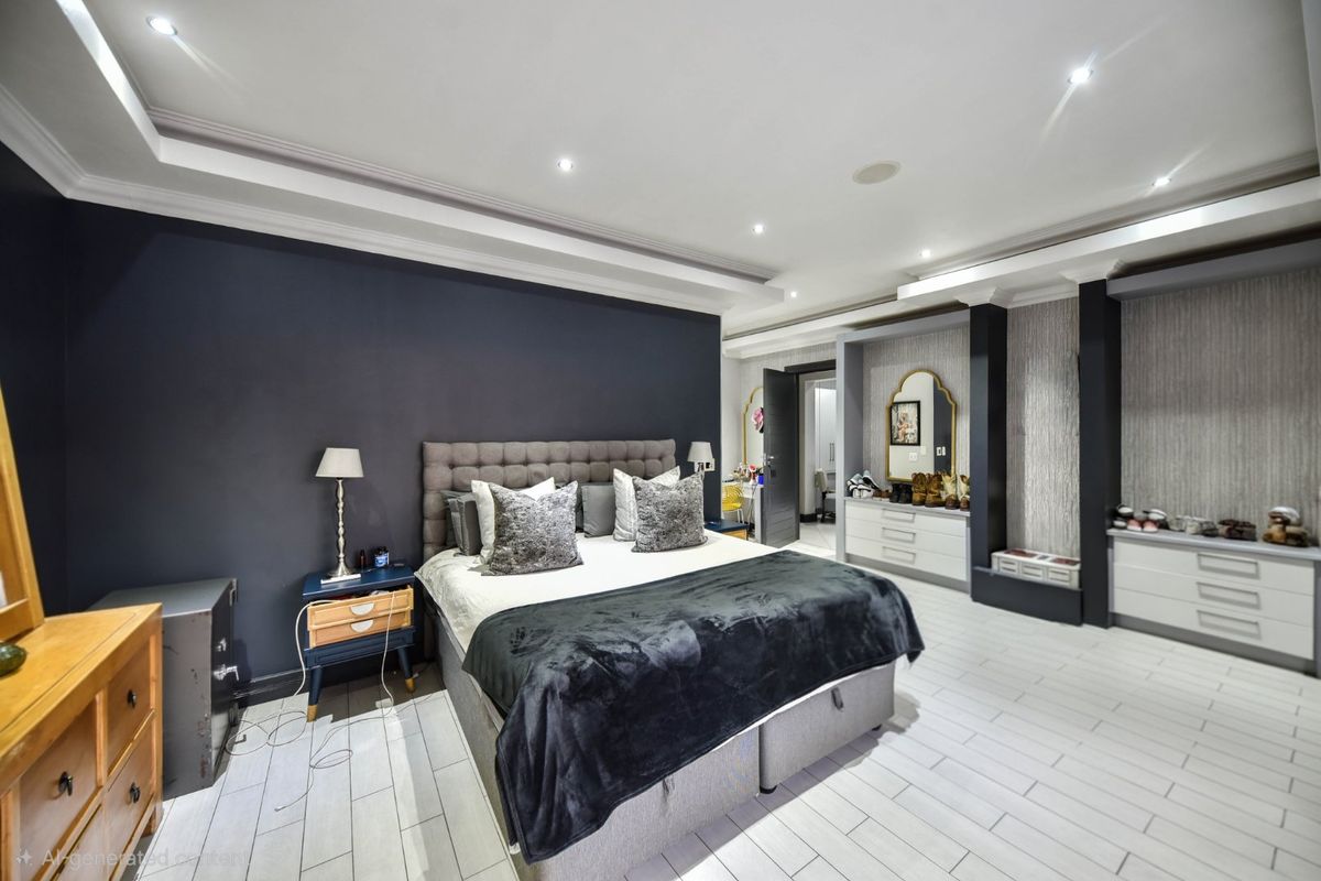 Spacious primary bedroom featuring modern dark accent wall, recessed ceiling lighting, built-in storage cabinetry, and light-toned tiled flooring.