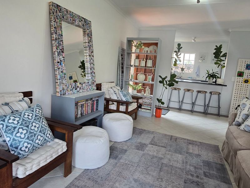 Open-plan living area featuring tiled flooring and a breakfast bar connecting to the kitchen space.