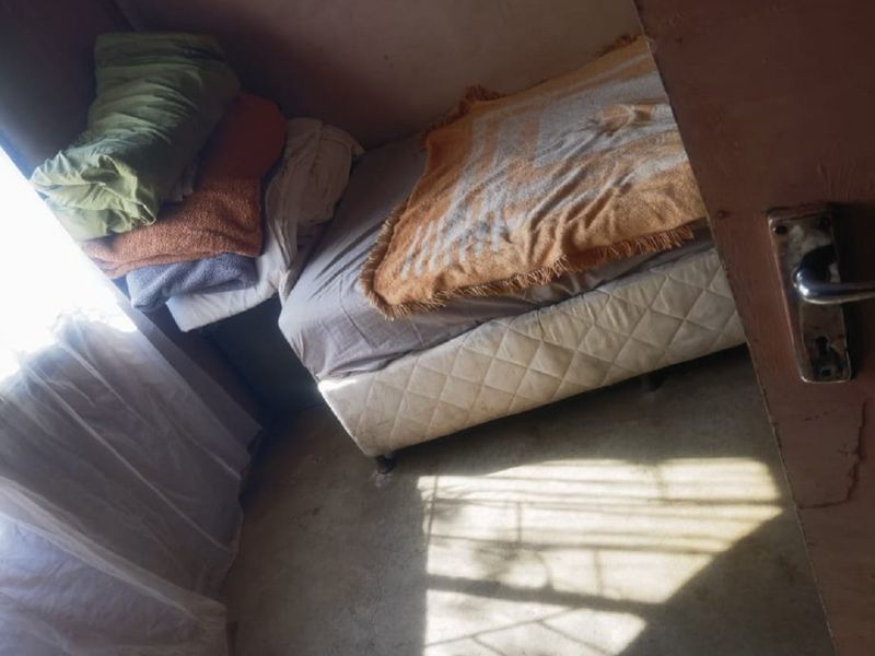 A small bedroom featuring a concrete floor and basic wall finishes, requiring cosmetic updates and maintenance to improve the overall living space.