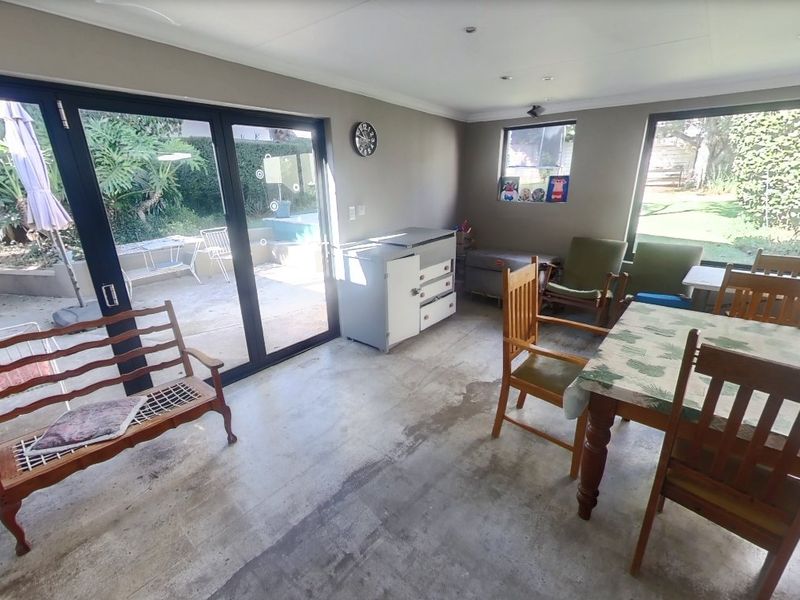 Spacious living area featuring large windows and sliding glass doors that provide ample natural light and direct access to the garden.