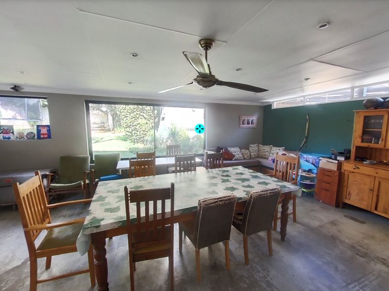 Spacious living area featuring a ceiling fan, recessed lighting, and large sliding glass doors providing natural light and garden views.