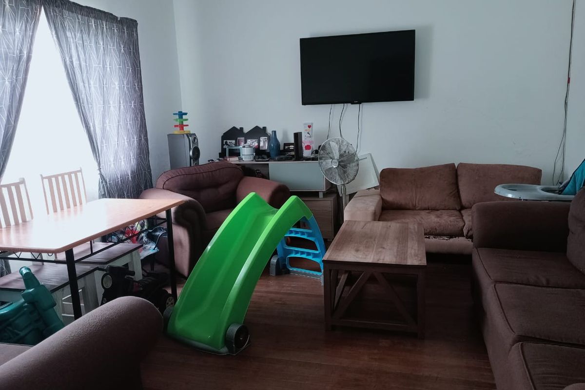 A living room featuring laminate flooring and a wall-mounted television, offering a functional space for relaxation and family activities.