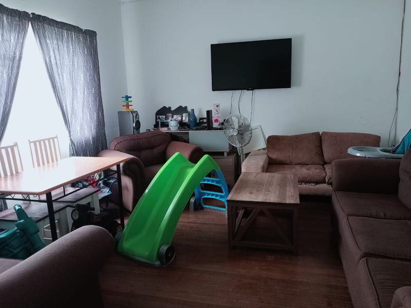 A living room featuring laminate flooring and a wall-mounted television, offering a functional space for relaxation and family activities.