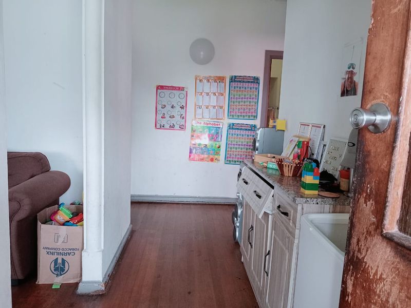 A functional laundry area featuring built-in cabinetry with stone countertops and laminate flooring, currently used as a multi-purpose utility space.