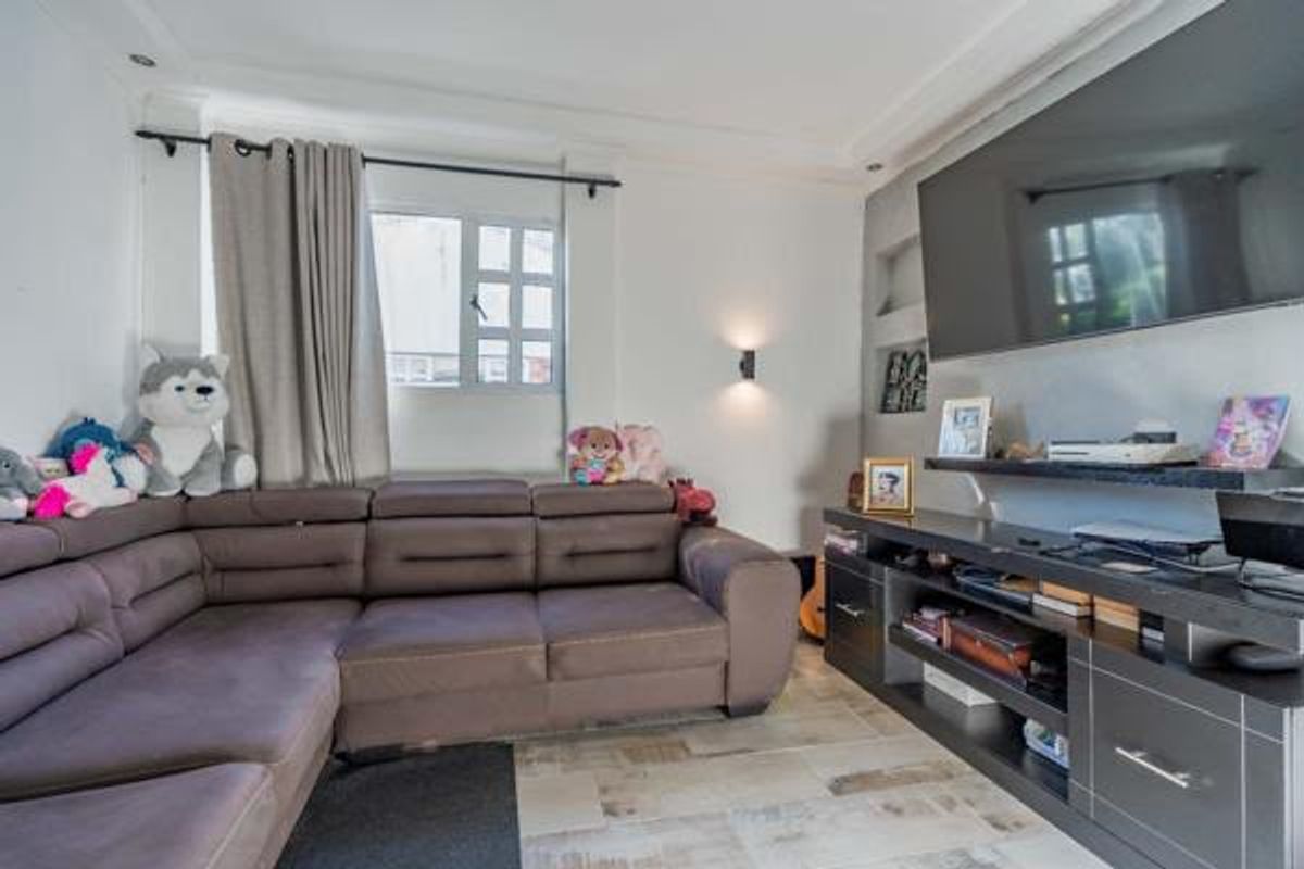 A comfortable living room featuring tiled flooring, recessed wall shelving, and wall-mounted lighting, providing a functional space for relaxation.