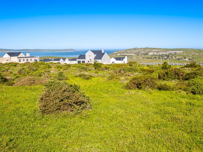 A scenic view of the coastal landscape and surrounding residential development from the vacant land plot.