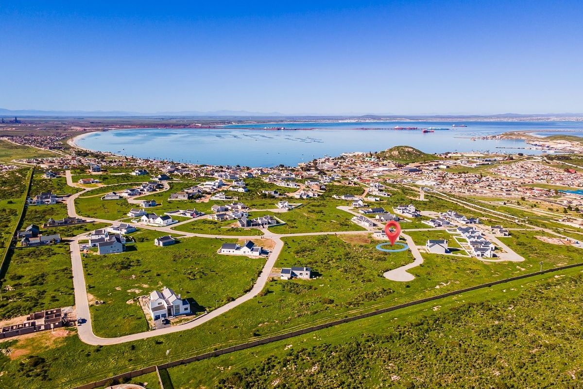 Aerial view of a residential development plot situated in a coastal estate with established road infrastructure and scenic bay views.