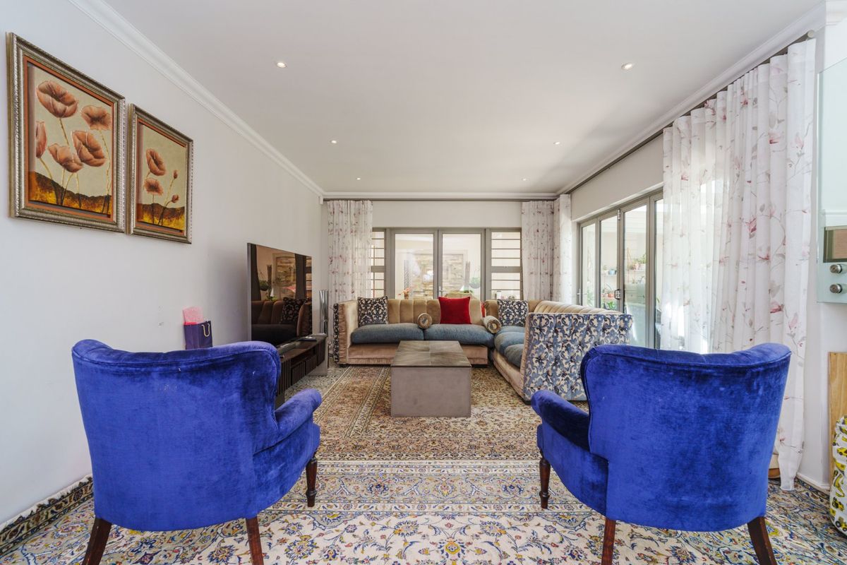 A well-maintained living room featuring recessed downlighting, crown molding, and large sliding glass doors that provide ample natural light and access to the outdoors.