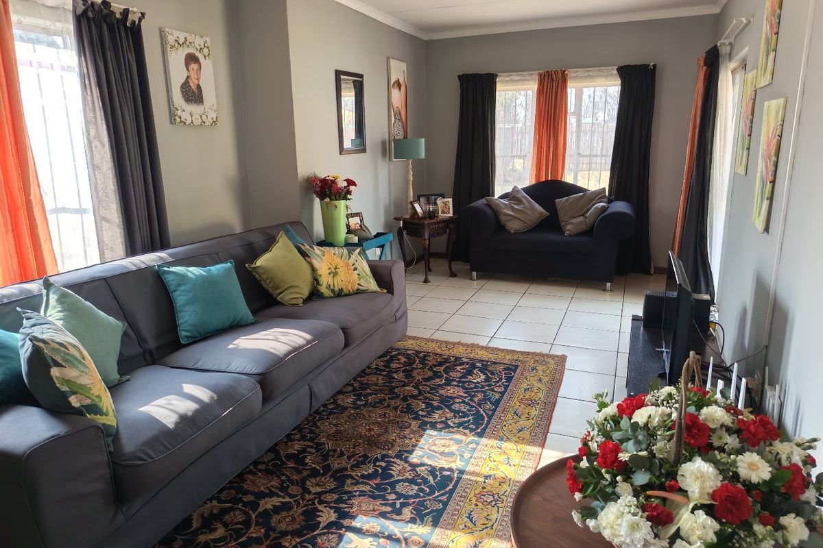 A comfortable living room featuring tiled flooring and natural light, providing a functional space for relaxation and family gatherings.