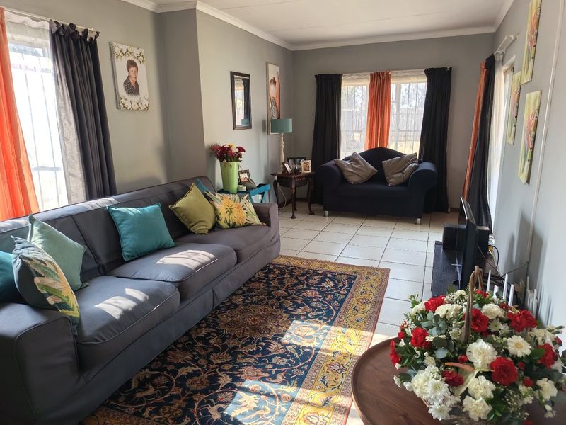 A comfortable living room featuring tiled flooring and natural light, providing a functional space for relaxation and family gatherings.