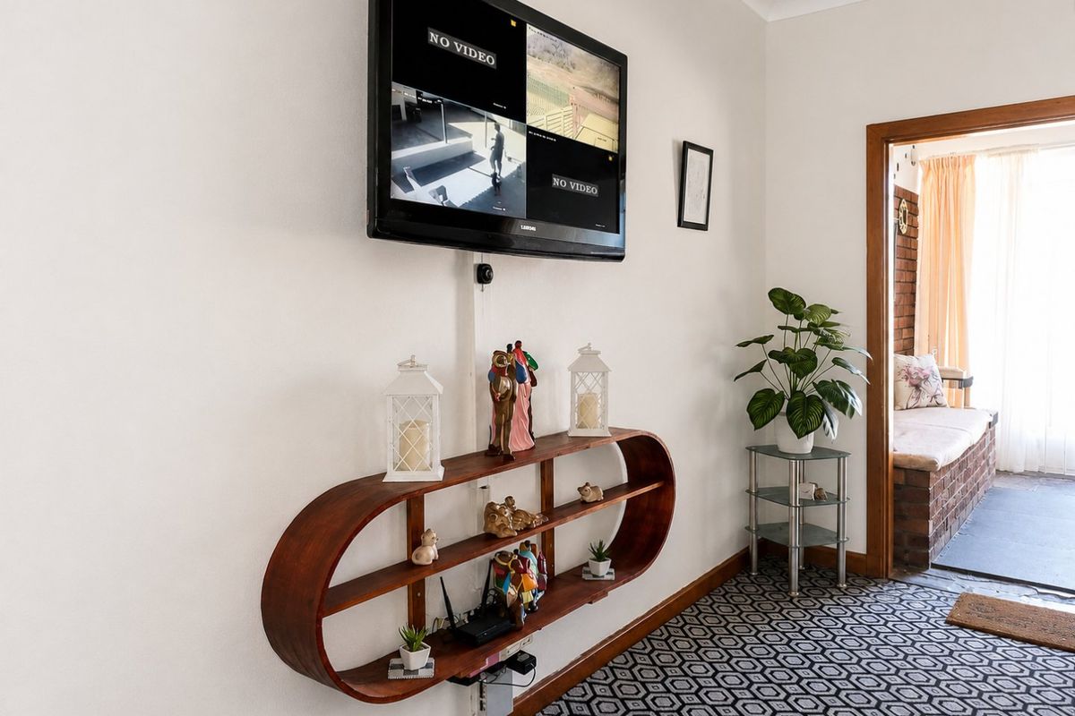 A living area featuring patterned carpeting and a doorway leading to an adjacent sunroom or patio space.