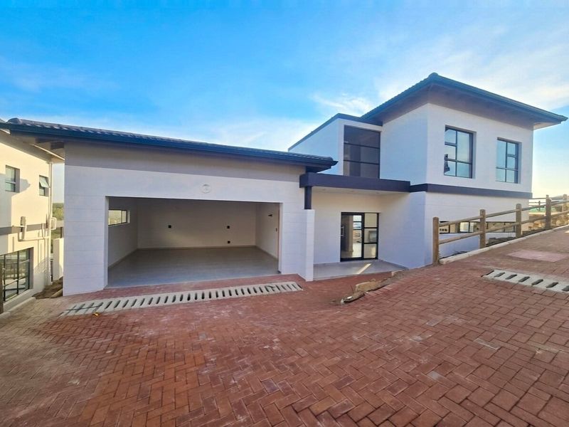 Modern double-story home featuring a spacious double garage, paved driveway, and contemporary architectural design with clean lines and neutral finishes.