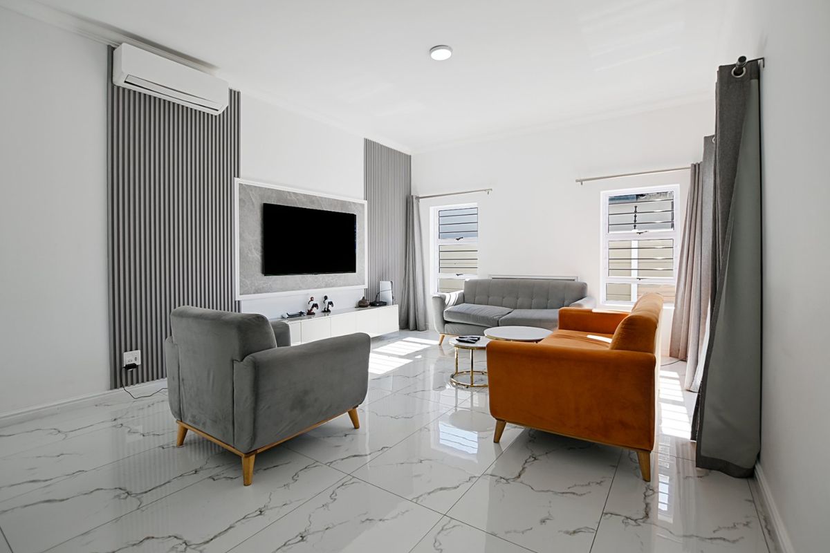 Modern living room featuring high-gloss marble-look floor tiles, decorative slatted wall paneling, and a wall-mounted split-system air conditioner.