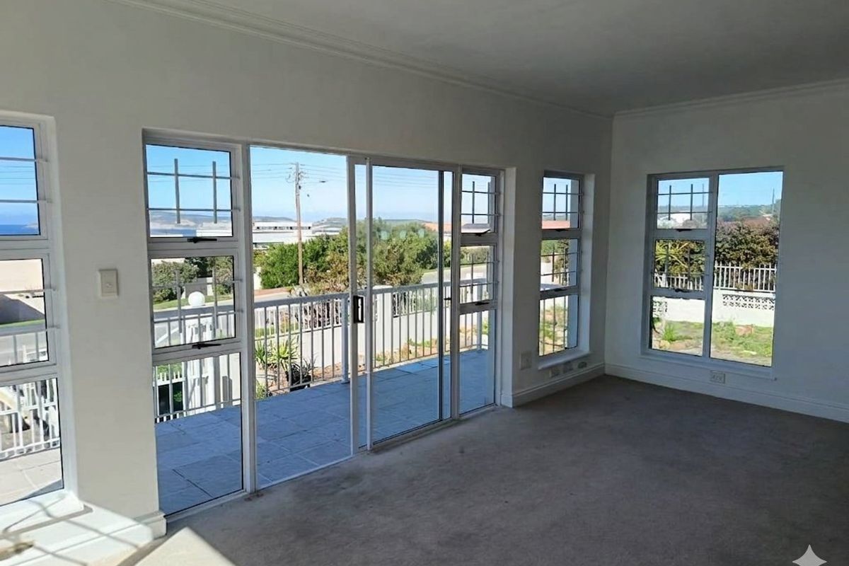 Bright and spacious living area featuring large sliding glass doors that open onto a balcony, offering natural light and scenic views.