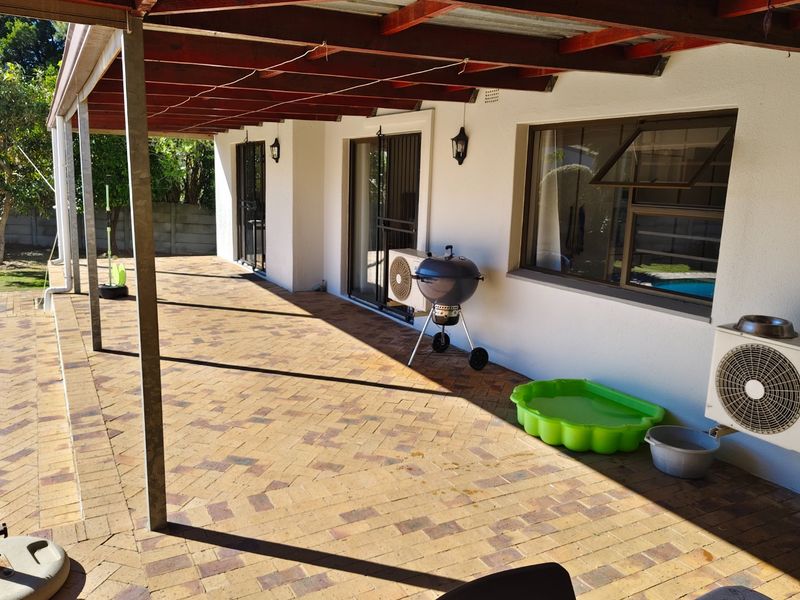 A spacious covered patio featuring brick paving and a timber pergola, providing an ideal outdoor area for entertaining and relaxation.