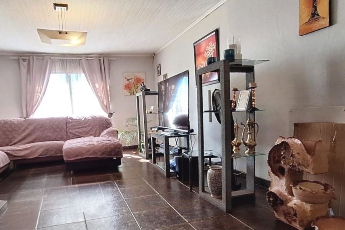 A living room featuring tiled flooring, a split-system air conditioner, and a tongue and groove ceiling.