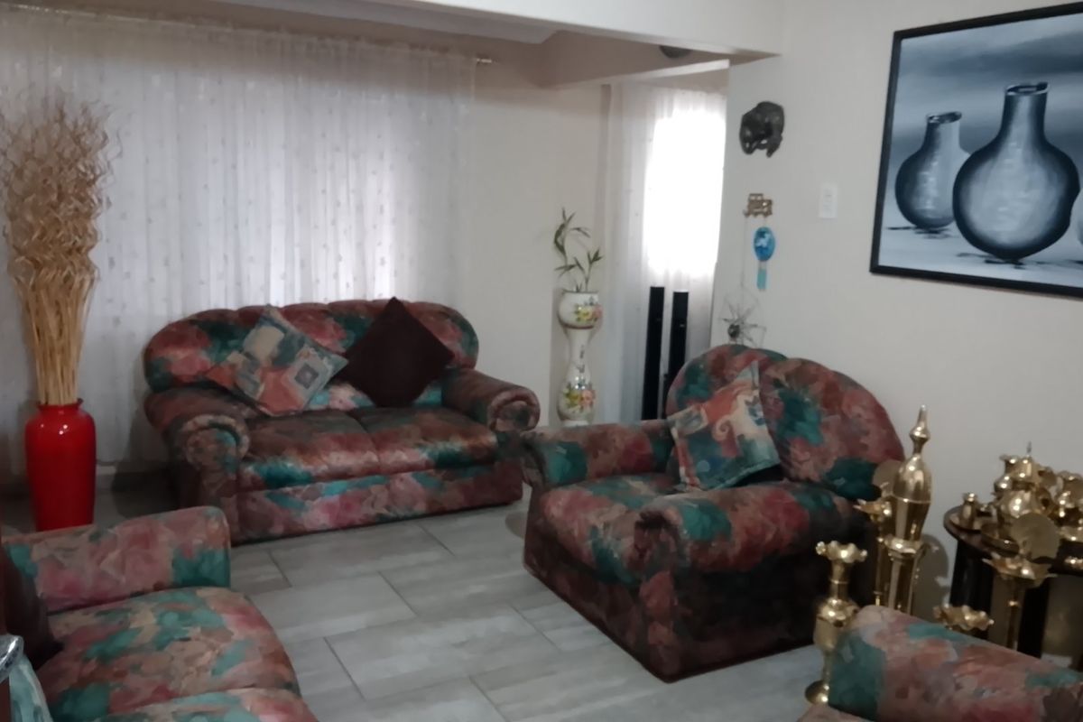 A living room area featuring tiled flooring and neutral wall finishes, providing a functional space for relaxation.