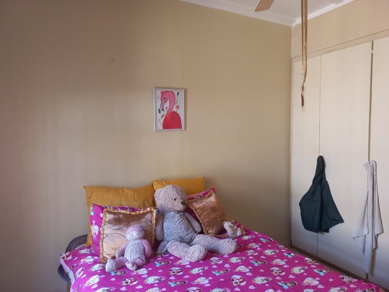 A standard bedroom featuring built-in cupboards and a ceiling fan, providing functional storage and climate control.
