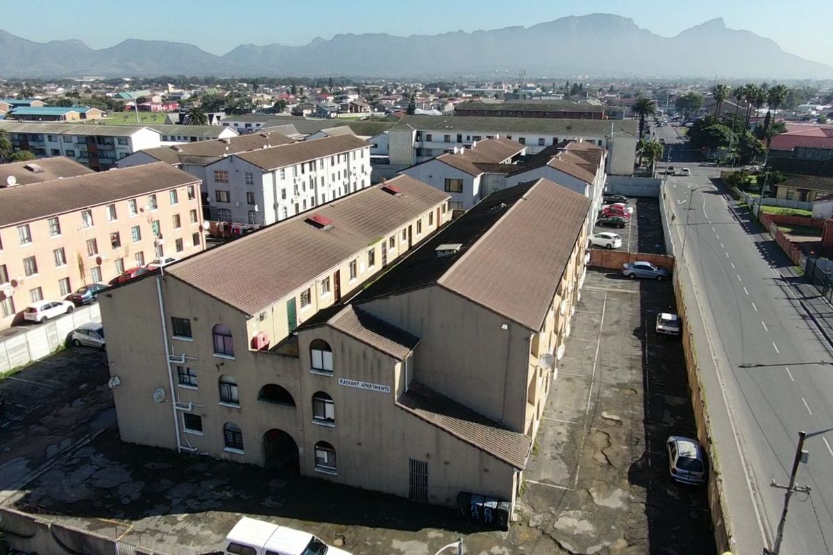 Aerial view of the Radiant Apartments complex, featuring multi-story residential blocks, a paved parking area, and surrounding neighborhood infrastructure.