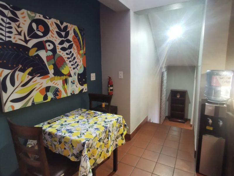 A tiled hallway area featuring a staircase and wall-mounted fire safety equipment, providing access to different levels of the home.