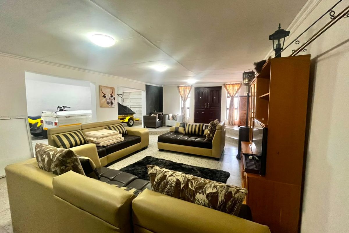Spacious living area featuring tiled flooring and a double door entrance, offering an open-plan layout with direct access to adjacent utility or garage space.