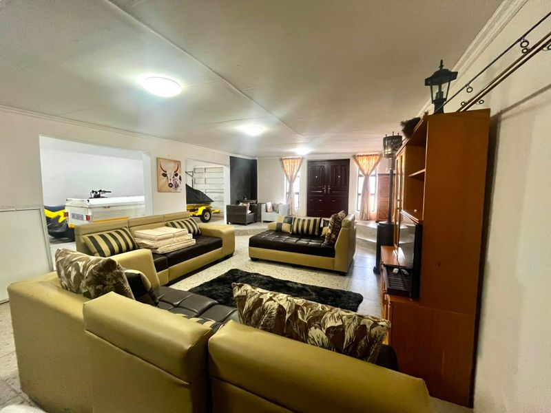 Spacious living area featuring tiled flooring and a double door entrance, offering an open-plan layout with direct access to adjacent utility or garage space.