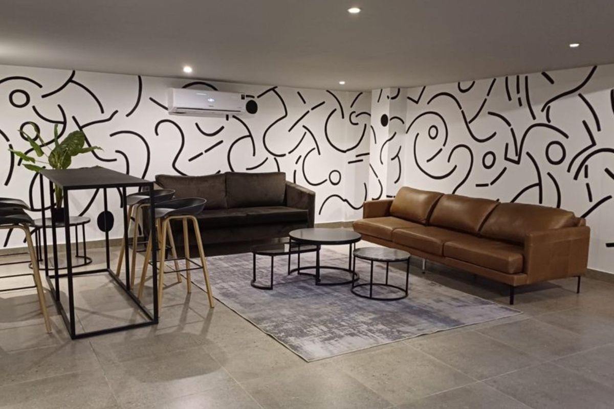 A modern living area featuring tiled flooring, recessed lighting, and a wall-mounted split-system air conditioner.