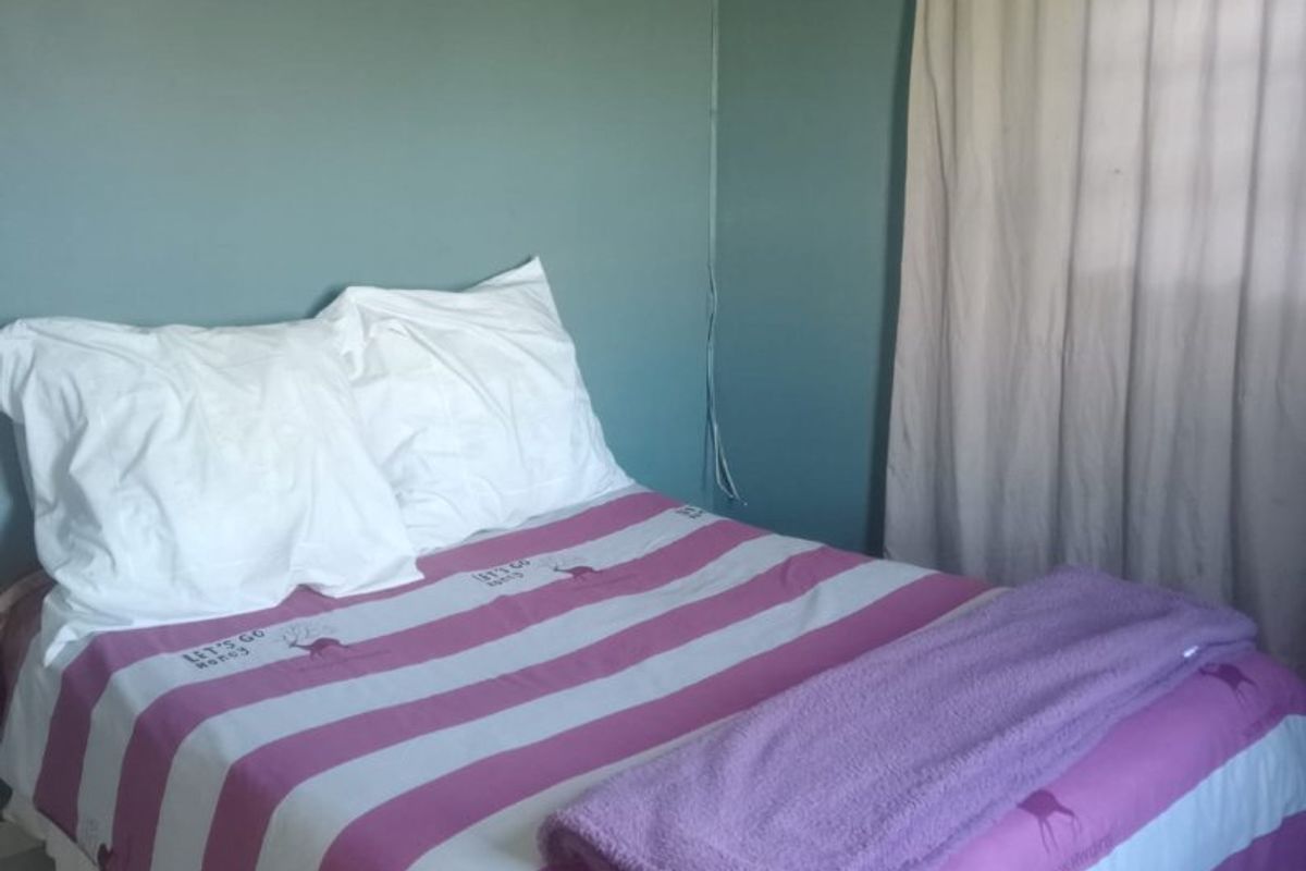 A bedroom featuring tiled flooring and painted walls, providing a functional space for rest.